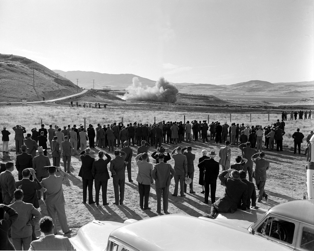 people watching rocket motor test in desert