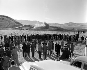 people watching rocket motor test in desert