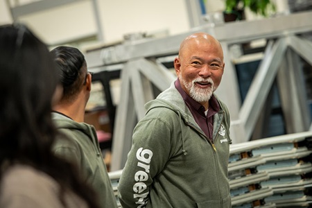 Man standing sideways and smiling. 