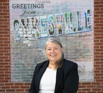 Female standing in front of Sykesville sign