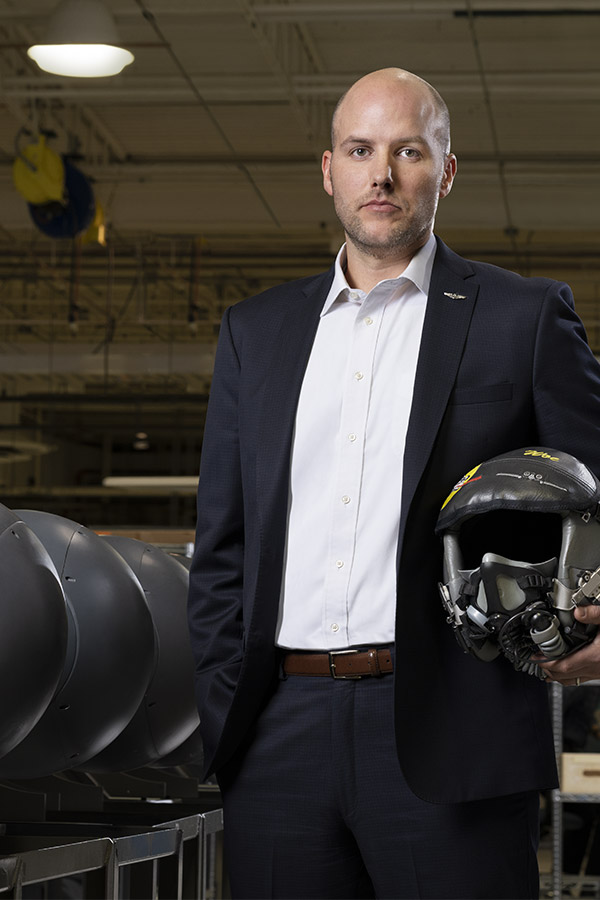 white man with bald head holding pilot helmet