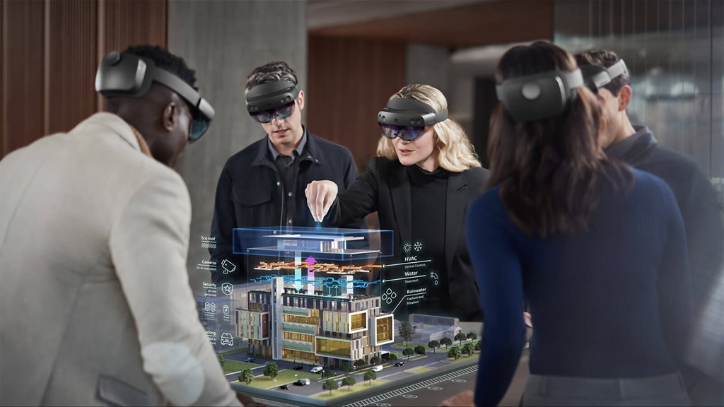 a group of people wearing HoloLens VR headsets stand around a digital image