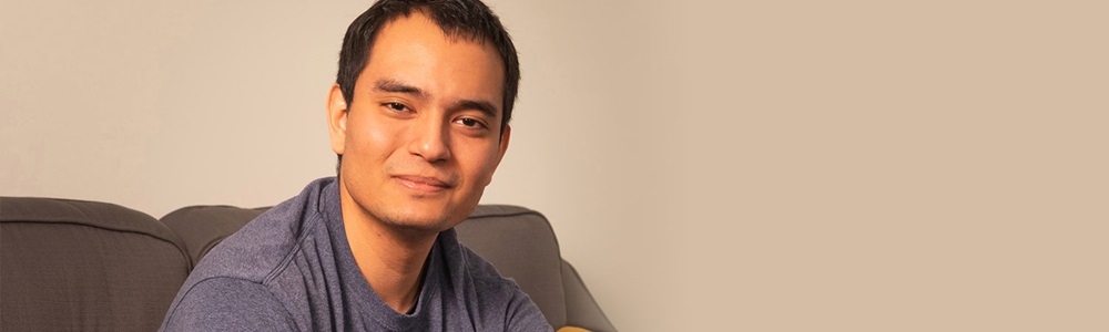 man smiling while sitting on couch