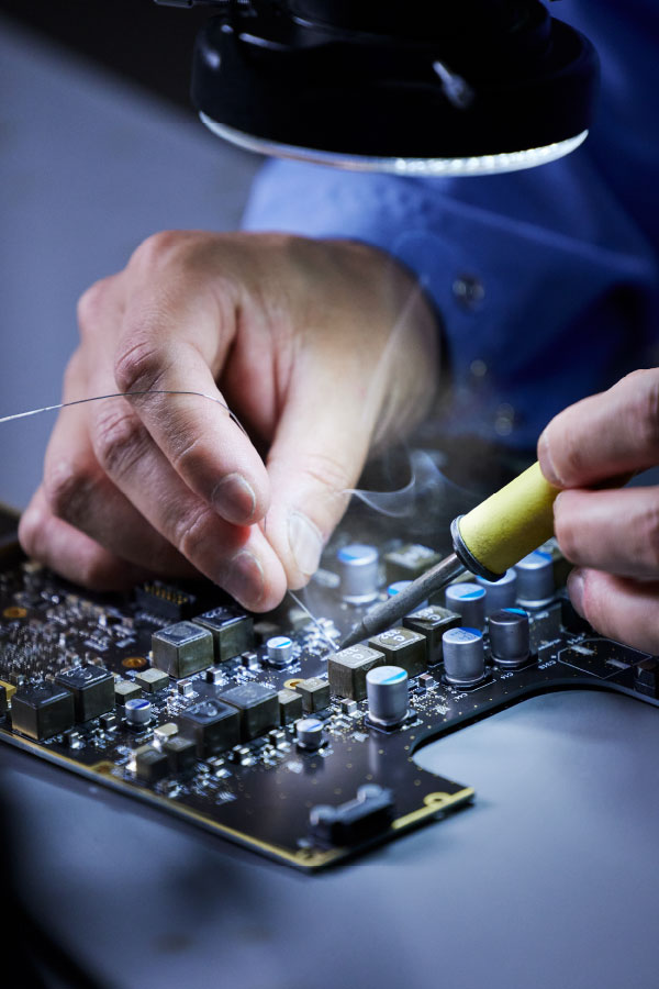 Close up of hand working on circuit board