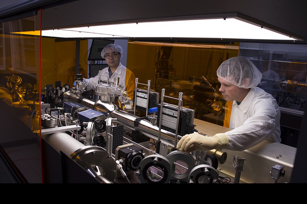 two male engineers working on laser hardware in factory