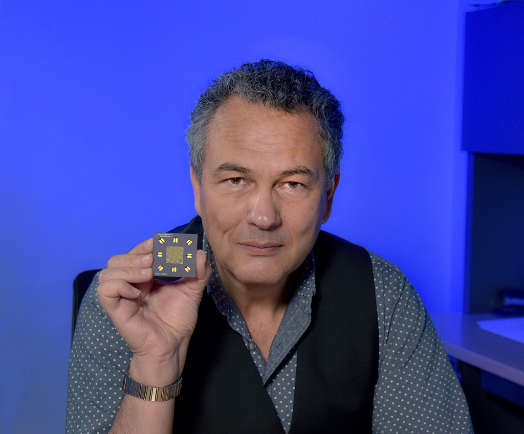 a man sitting in an office holds up a neuromorphic camera