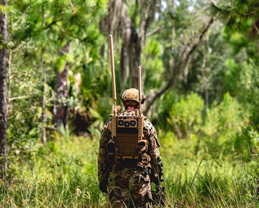 explosive ordnance disposal technician performs an improvised explosive device sweep in woods