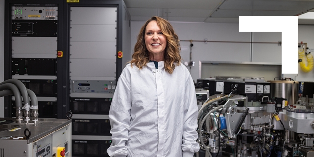 Smiling female wearing white lab coat standing in a lab