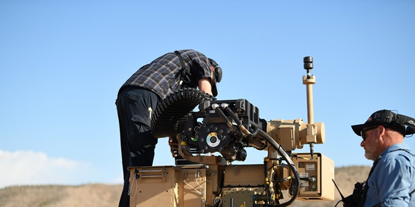 two males working on a large gun