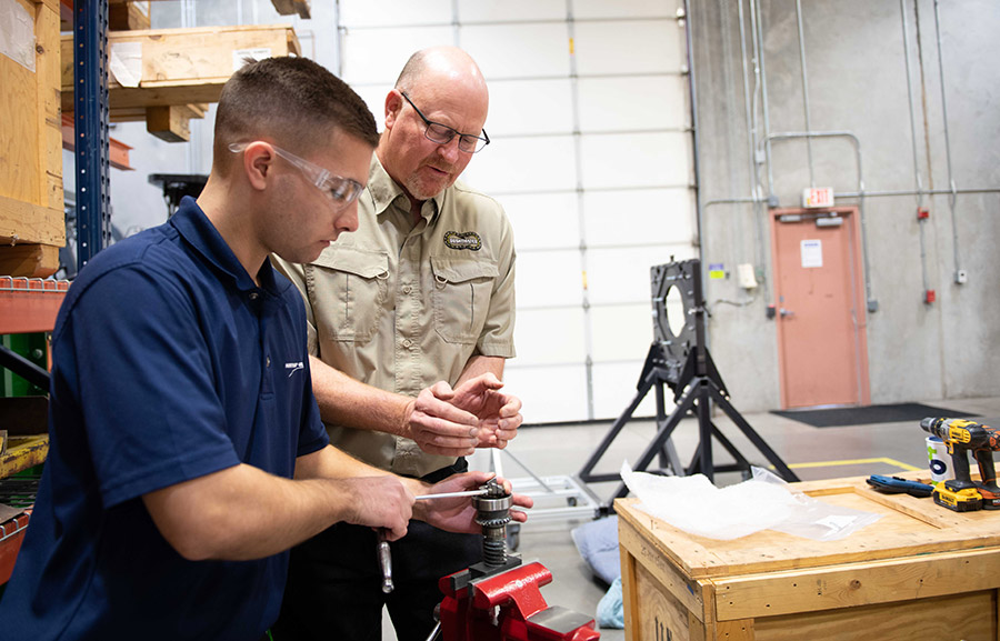 two males working on a weapon