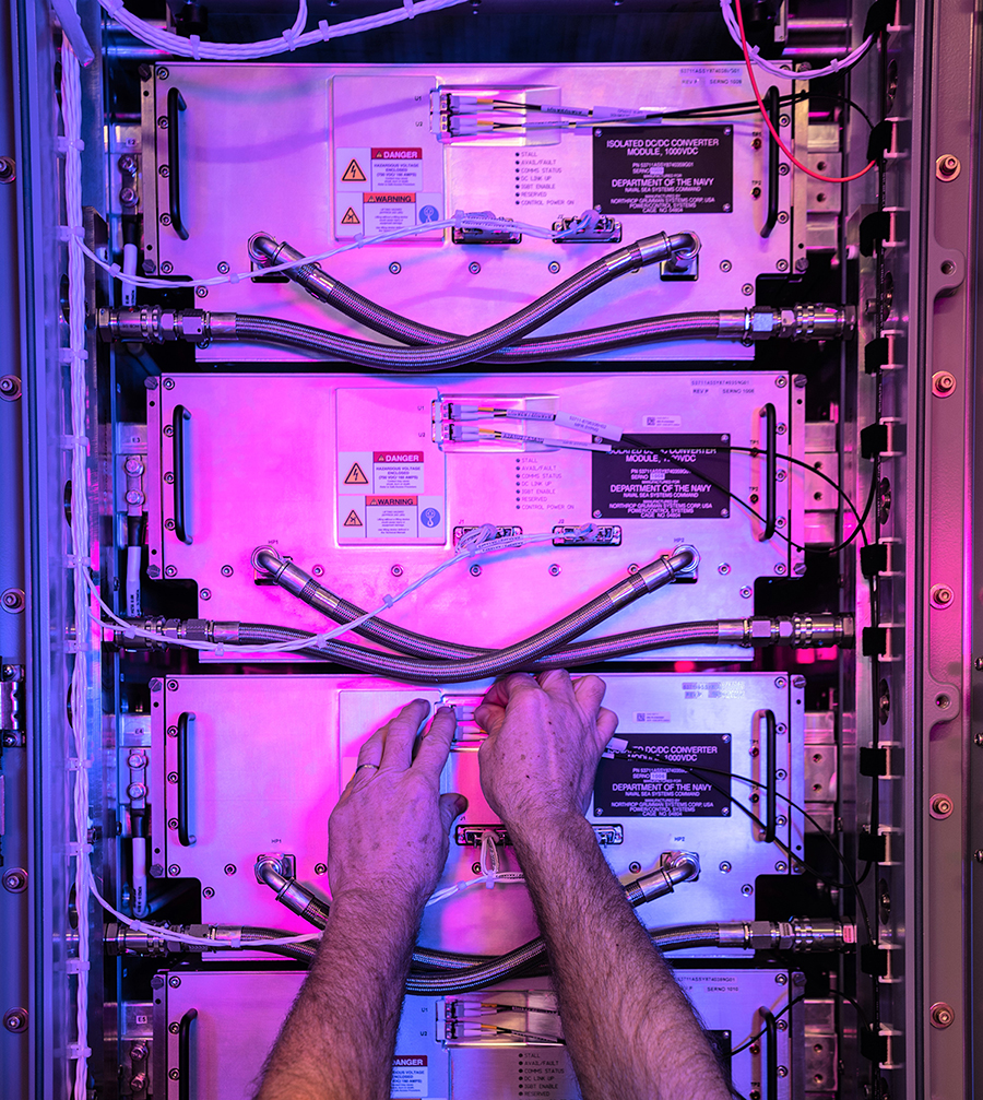 Employee's hands working on an electronics rack