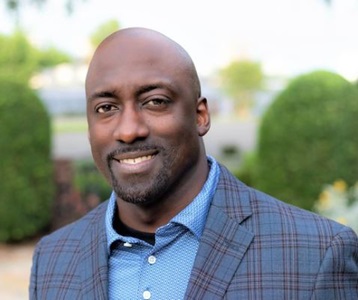 Black male in a blue plaid suit