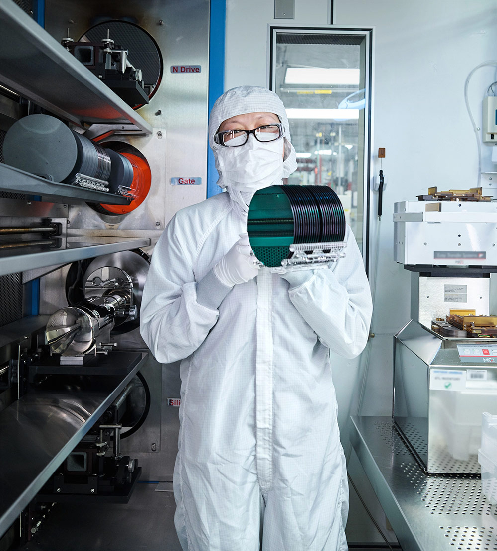 woman in clean suit holding microelectronics