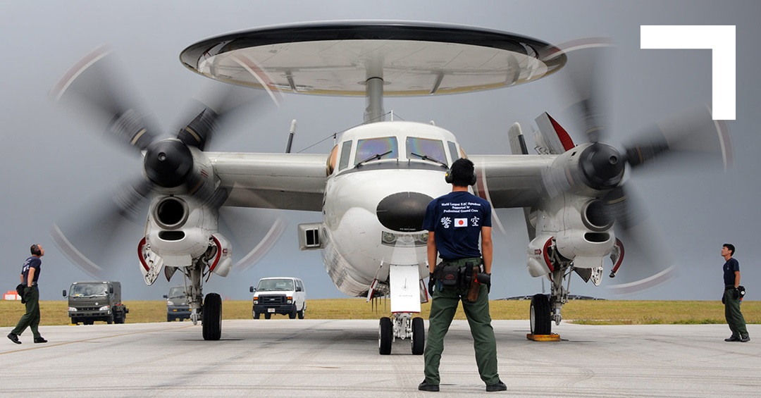 Man on tarmac standing in front of aircraft