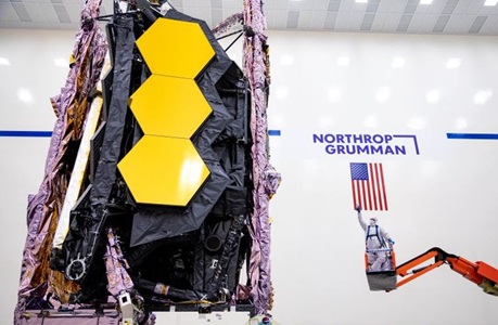 technicians dressed in a bunny suit working on a telescope