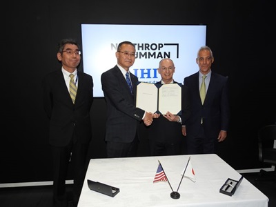 Four men hold certificate and shake hands