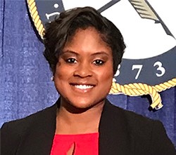 African American female smiling while holding award