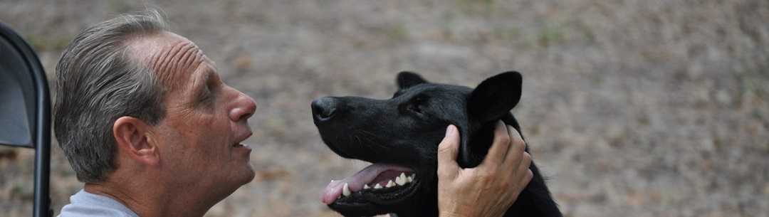 Caucasian Male Petting Black Dog