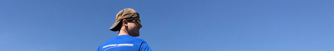 Caucasian Male side profile smiling against sky background