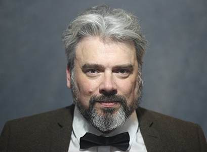Headshot of man in front of dark background