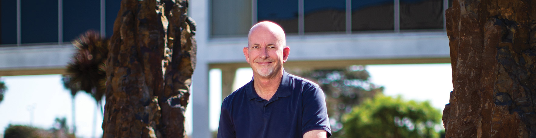 male standing and smiling