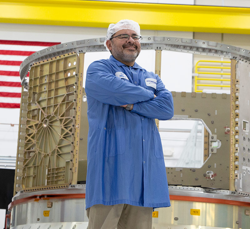 man in space lab wearing lab coat and smiling