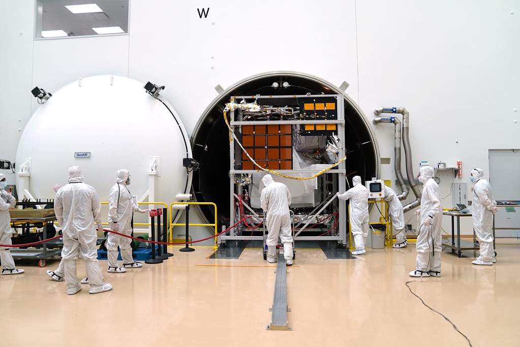 People in all white clean suits in a large white room