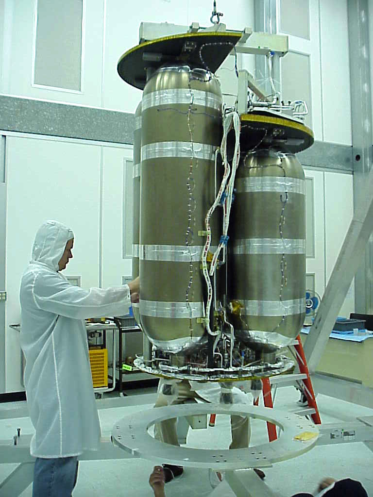 person in clean suit next to propulsion tanks