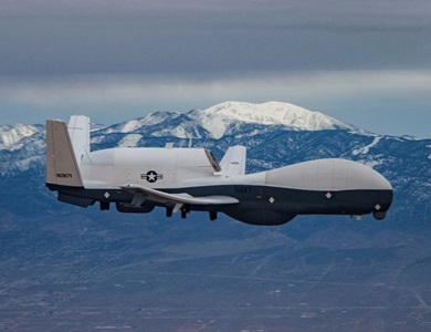 aircraft flying with snow capped mountains in background