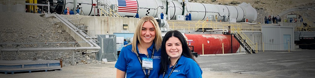 two women in front of rocket