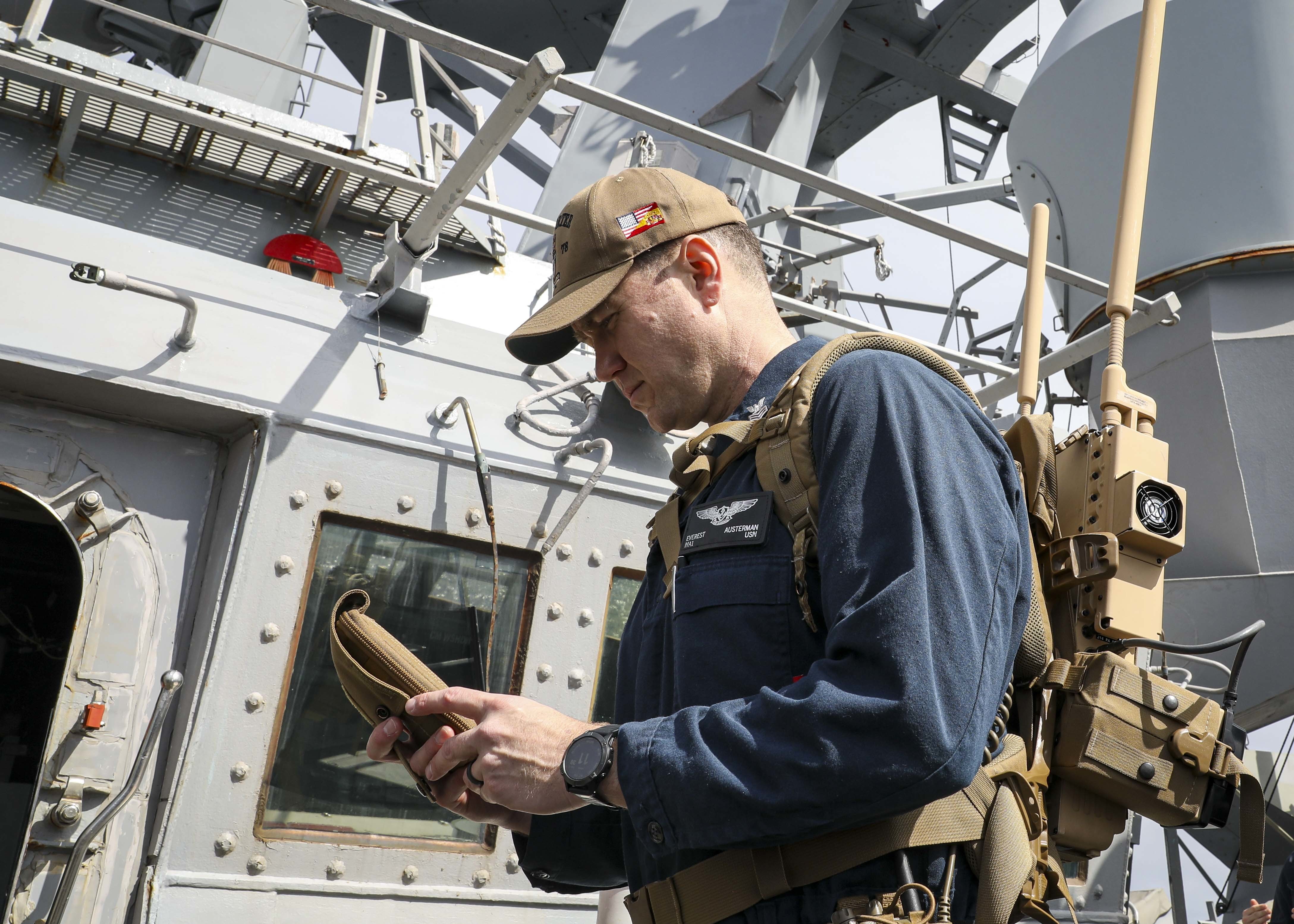 sailor operating anti-drone system on ship