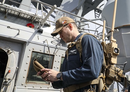 sailor operating anti-drone system on ship