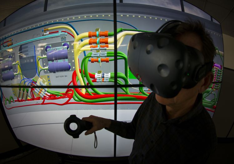 a man wears a VR headset in front of a computerized image