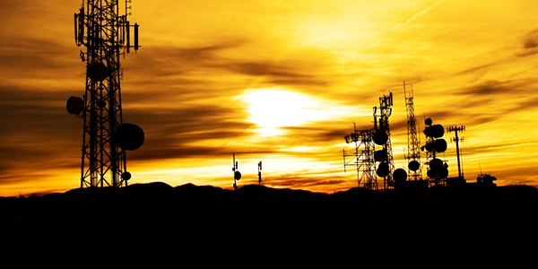 silhouette of transmission towers at sunset