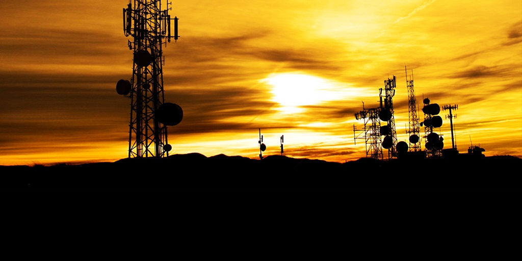 silhouette of transmission towers at sunset