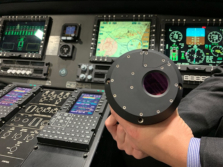 Advancing Survivability for Army Aircrews – A Generational Leap in Threat Detection Technology man holding sensor in front of electronic dashboard