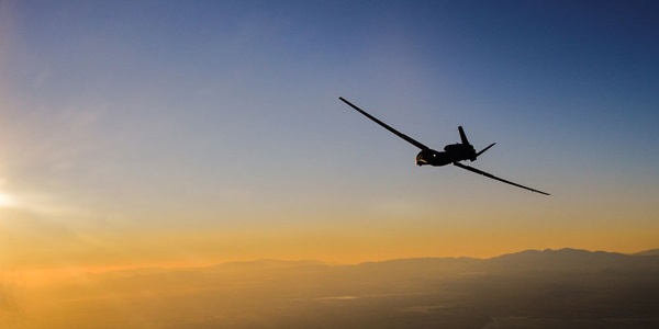 large military plane flying in sunset