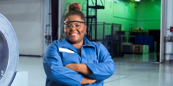 Woman standing with her arms crossed in a work uniform