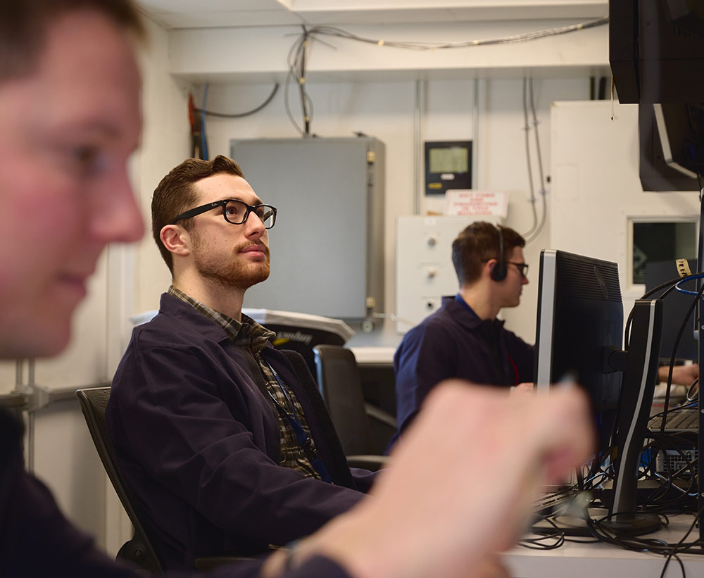 white man with glasses looking at monitor