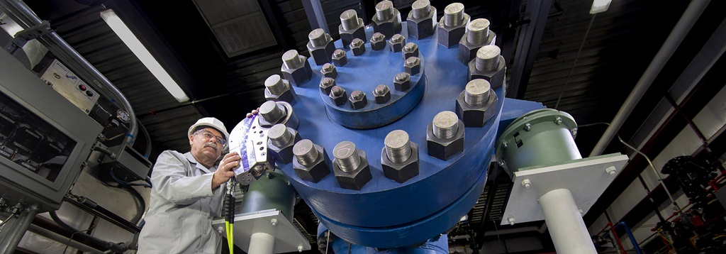 man standing in front of giant blue machine