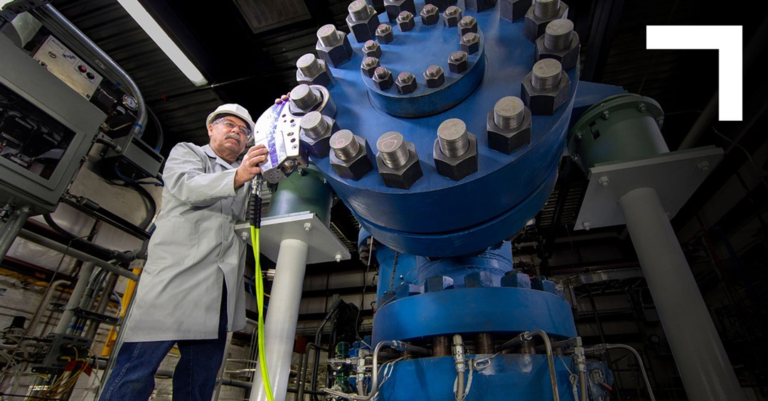 man in front of very large blue gear