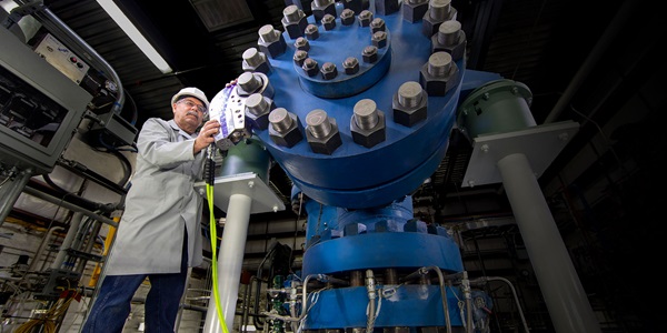 man standing in front of giant blue machine