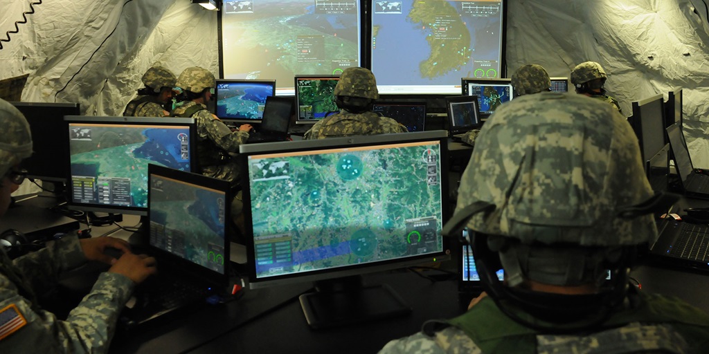 soldiers on computers in tent