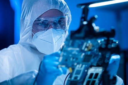 Microelectronics engineer holding up a small computer chip.