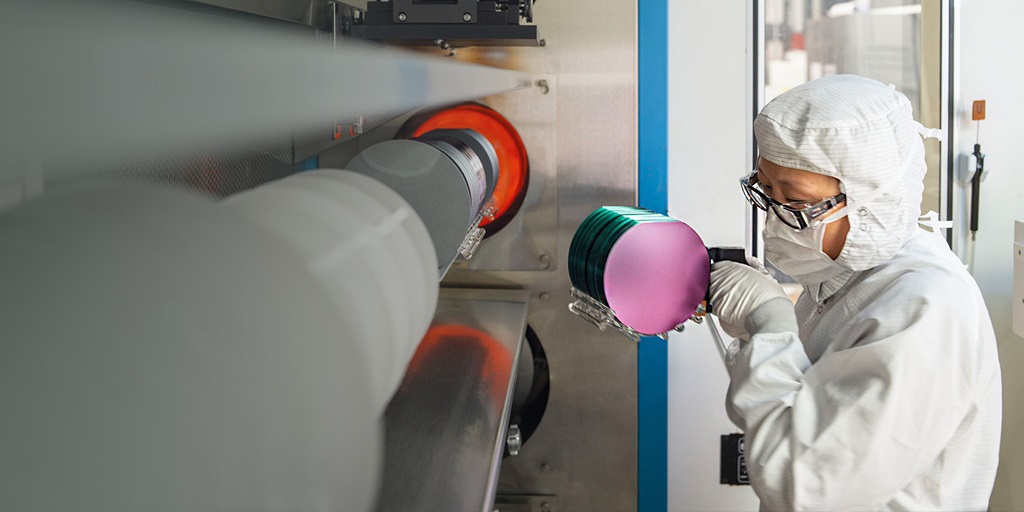 woman in lab suit holding micro disks