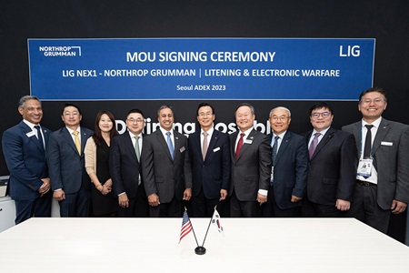 men and women in business suits lined up for photo under sign