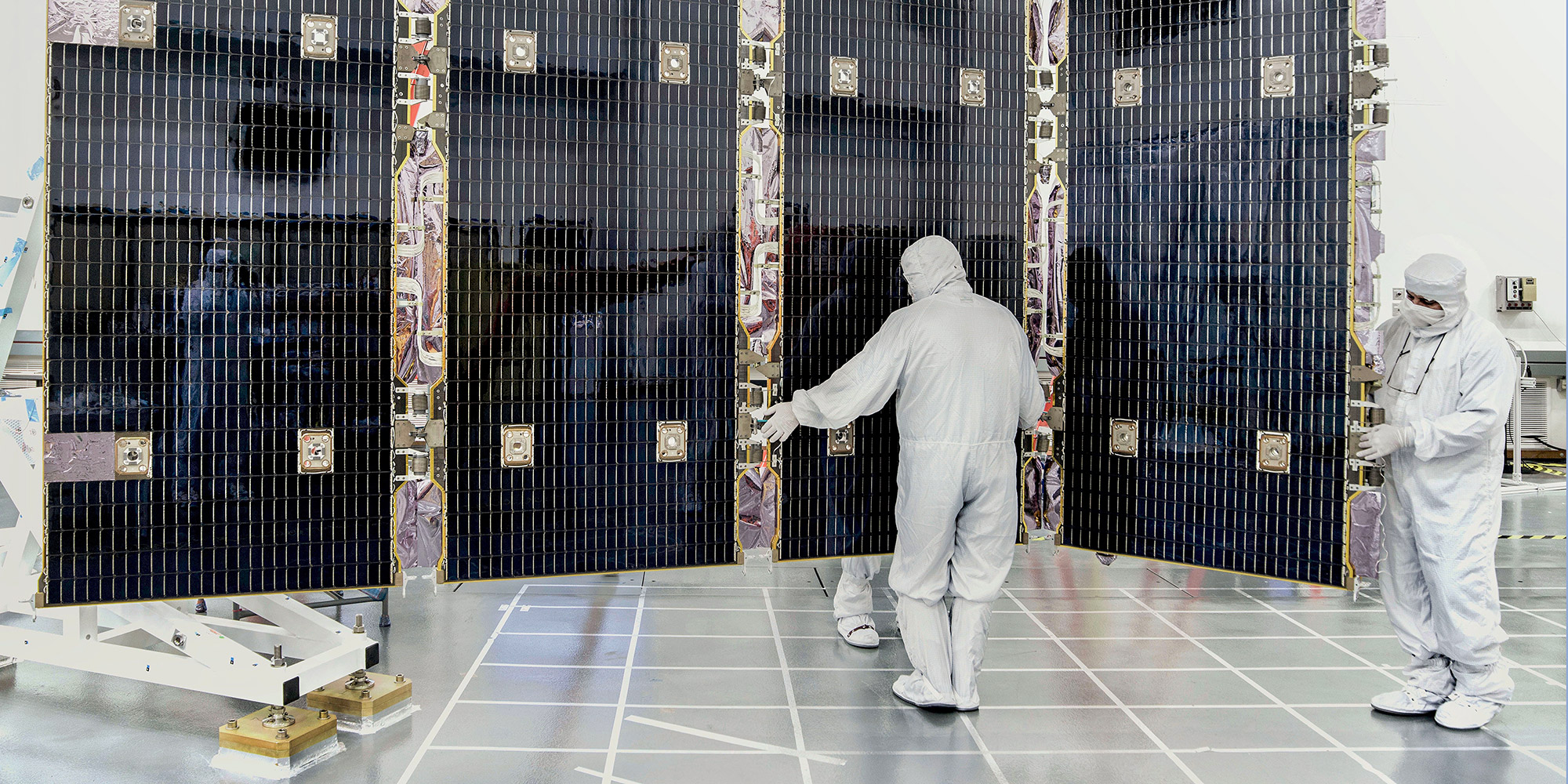 technician in bunnysuit working on a solar array