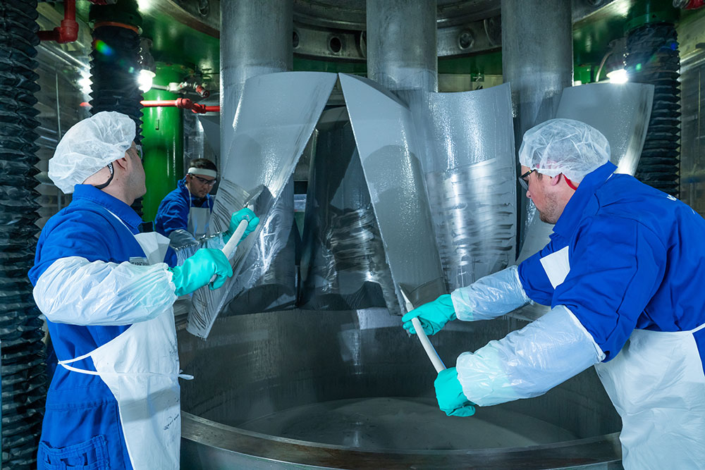 workers in cleans suits working on rocket motor