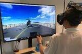 Young man using handheld mouse and Virtual Reality goggles to play on monitor screen