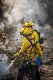 Three firefighters put out flames outside